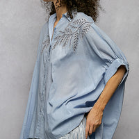 Sky blue button-down embroidered shirt with elbow-length sleeves and side drape