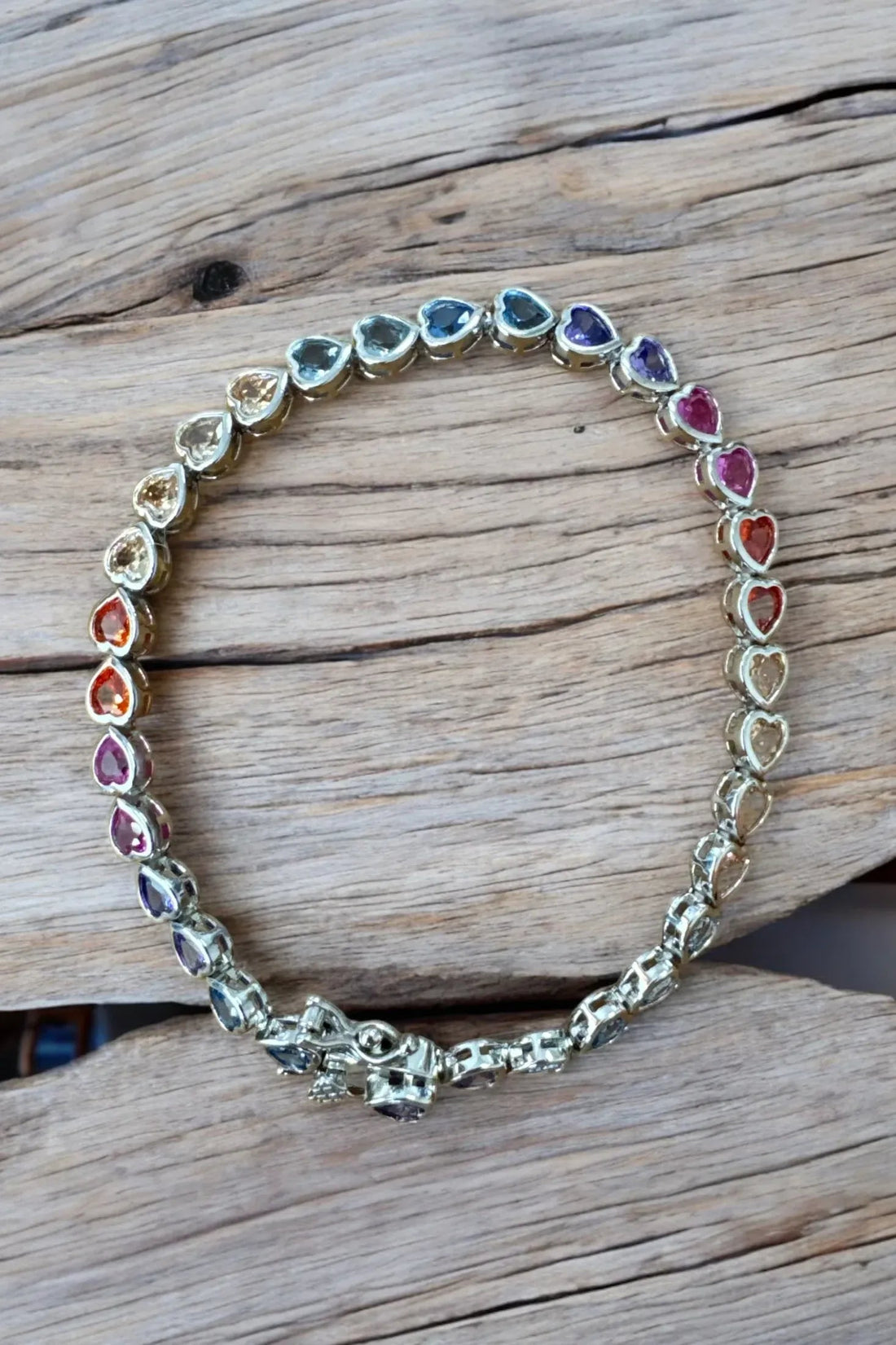 Silver heart tennis bracelet with oval multicolored stone links and heart accents
