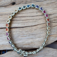 Silver heart tennis bracelet with oval multicolored stone links and heart accents