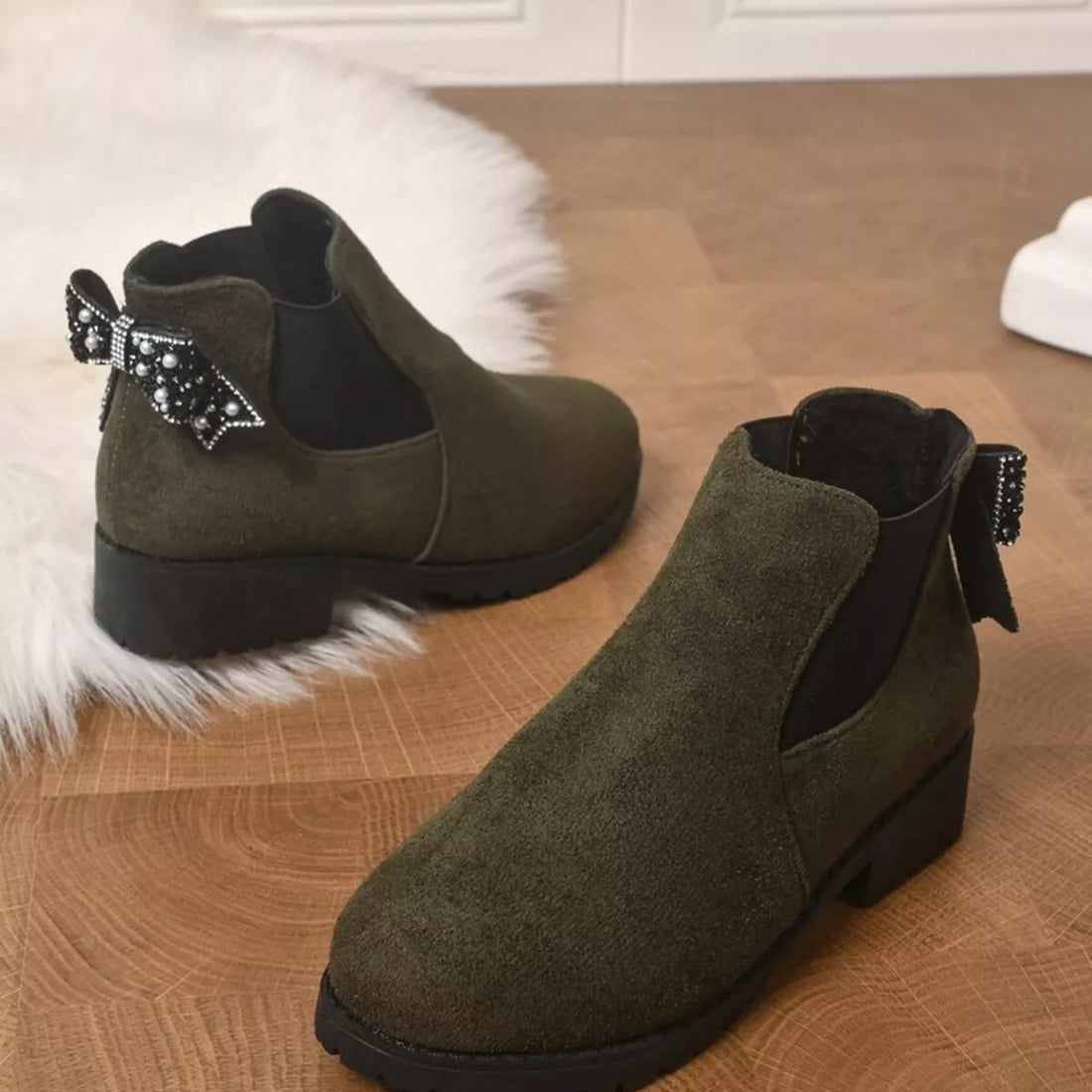 Olive suede ankle boots with round toe, block heel, and jeweled bow at collar