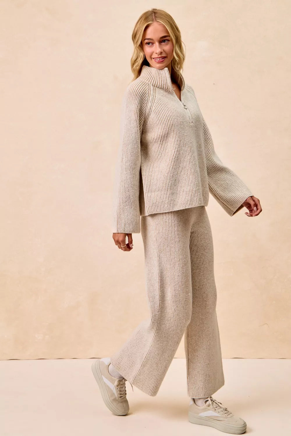 Two-tone taupe ribbed knit quarter-zip collared sweater top, walking pose