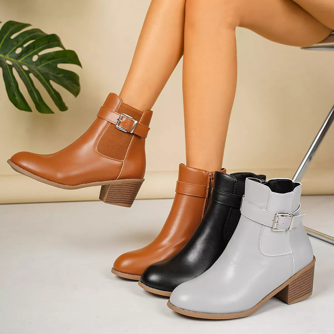 Point-toe block heel ankle boots with buckle straps, in brown, black, and gray