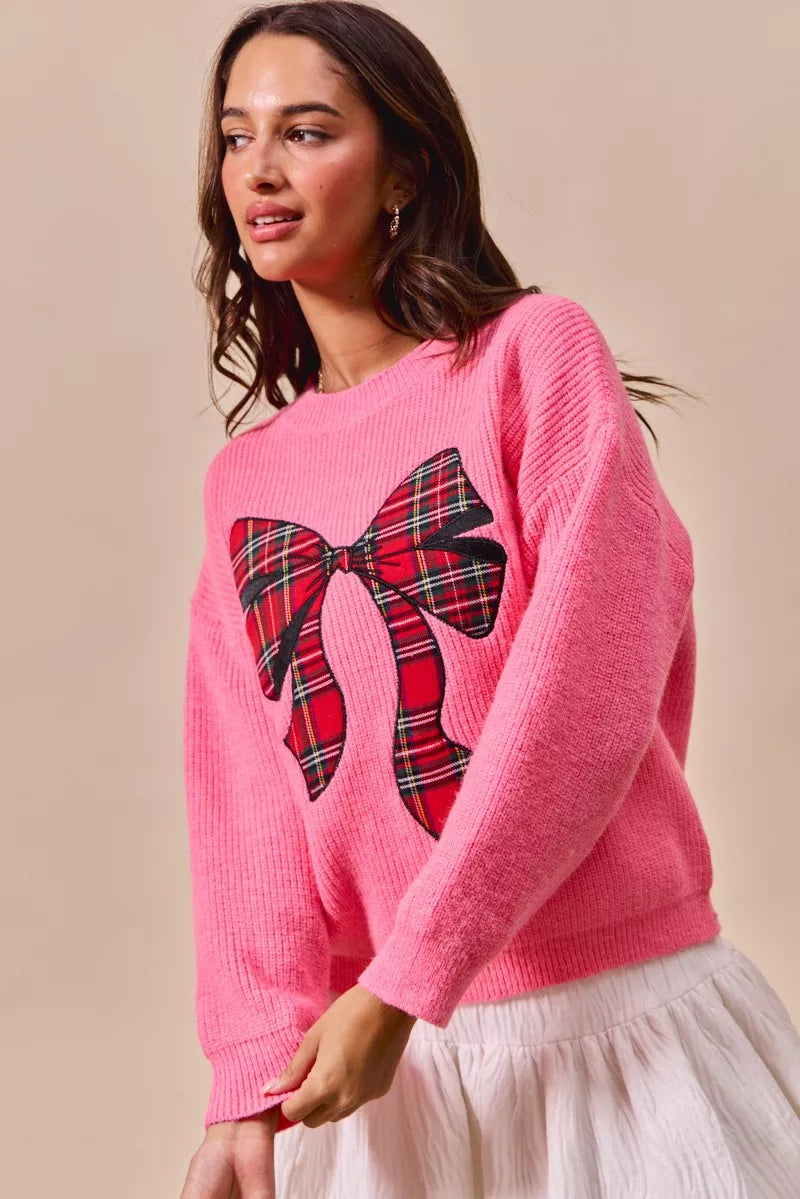 Pink knit sweater with plaid ribbon bow front and ribbed crew neckline