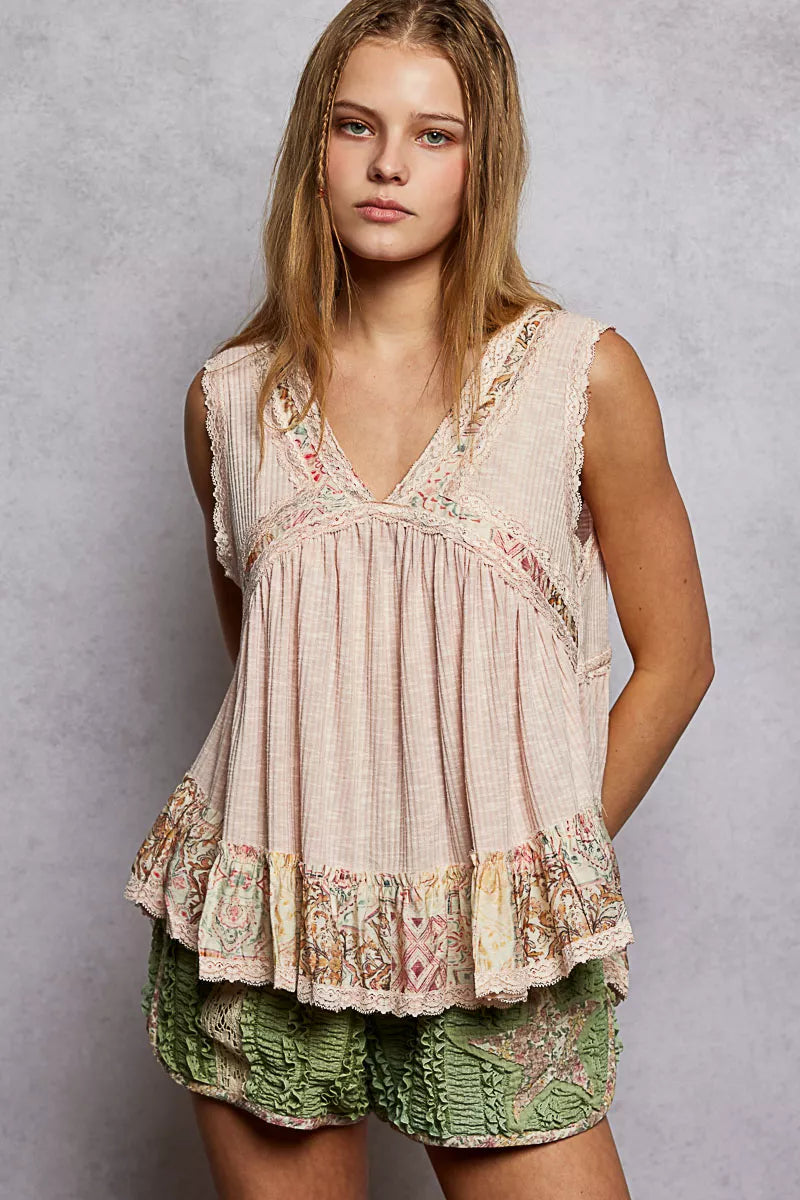 Pale pink sleeveless top with V-neck lace trim and ruffled floral hem