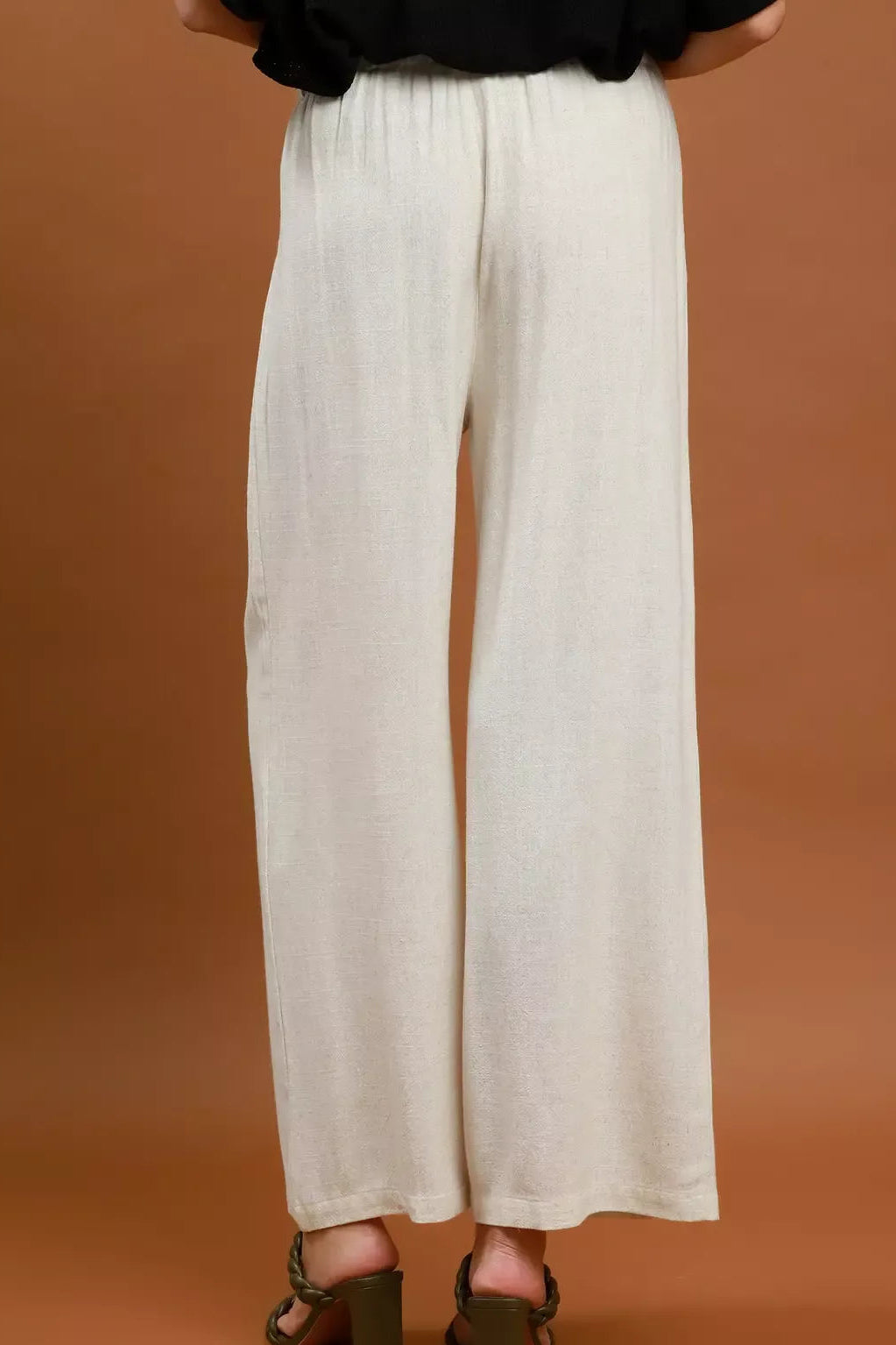 Cream high-waist wide-leg trousers with pleated front and wide straight legs