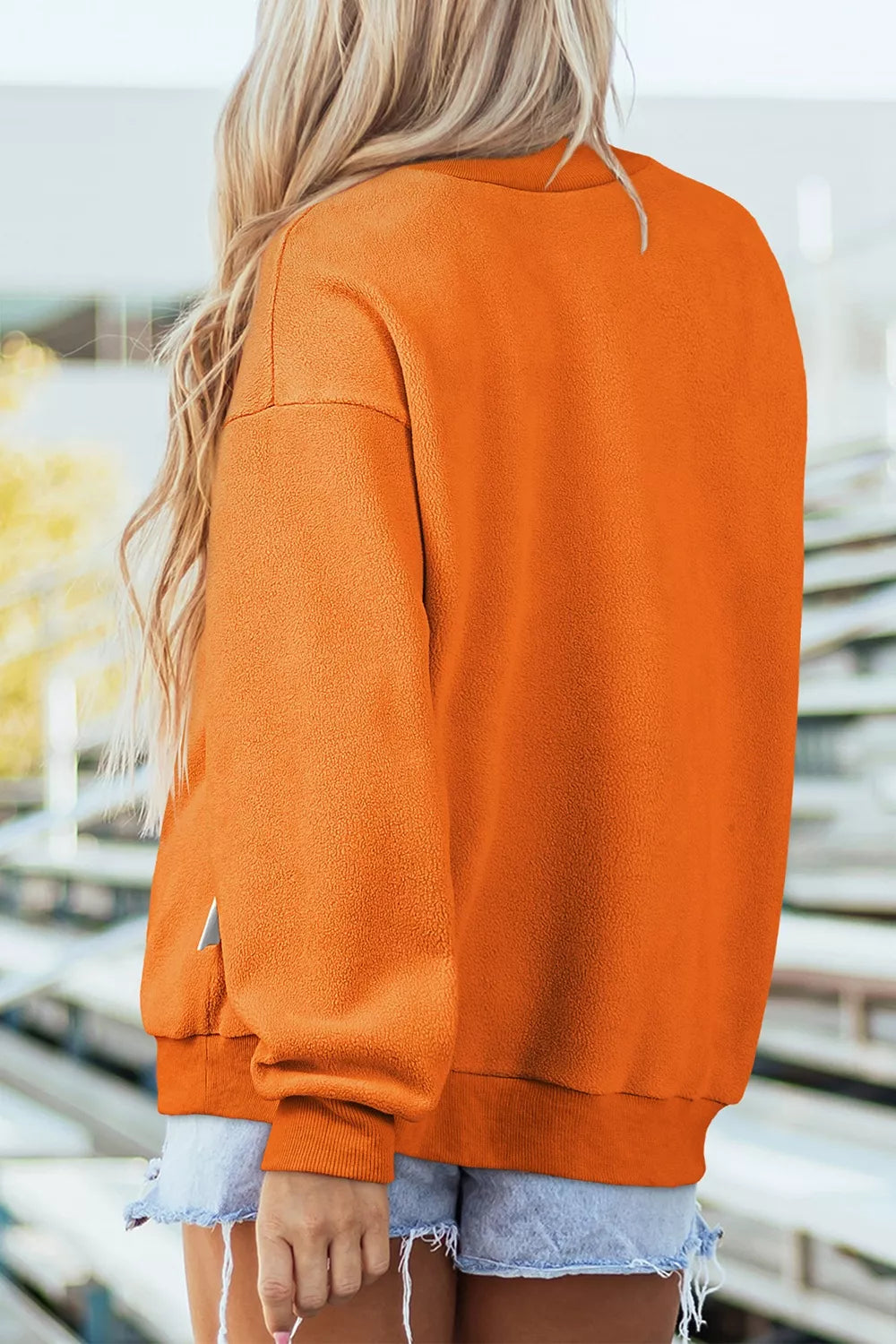 Orange mock neck sweatshirt back view, plain long sleeves and ribbed cuffs
