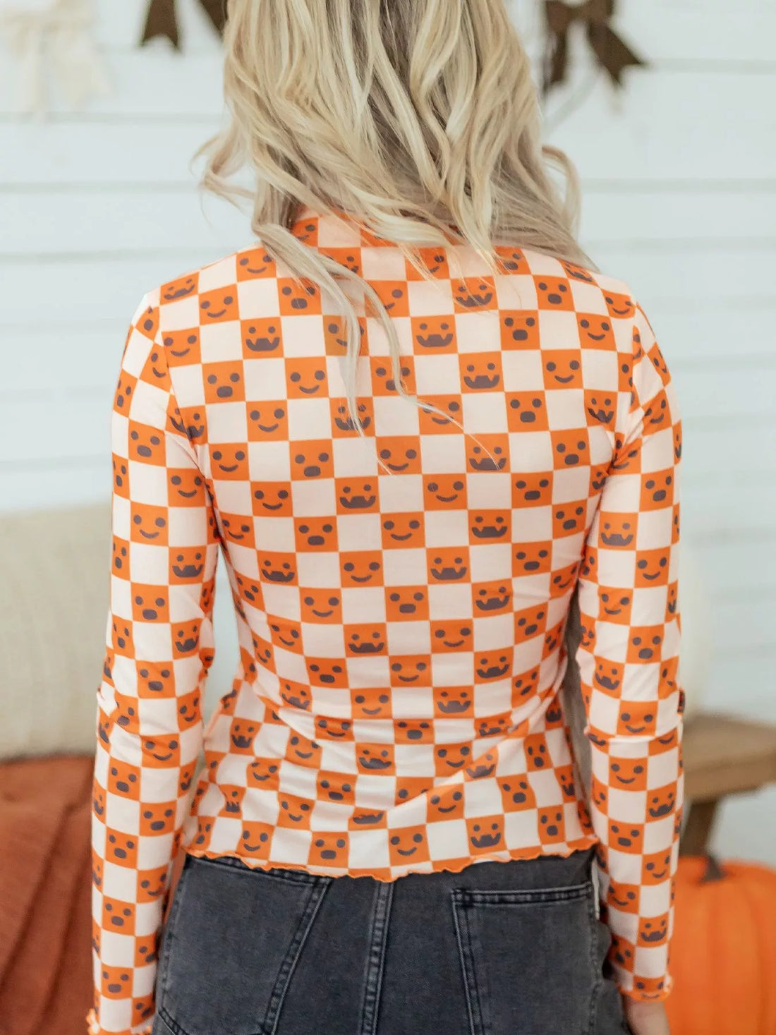 Halloween long sleeve mock neck blouse, back view, orange-and-white check with jack-o’-lantern faces