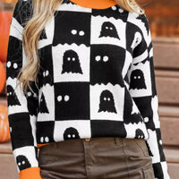 Black and white ghost checkerboard sweater featuring orange ribbed neckline and cuffs