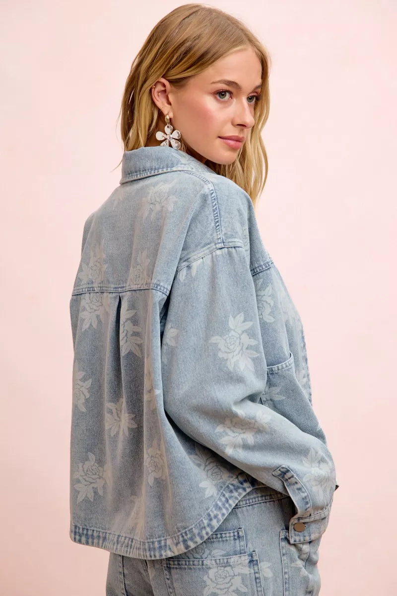 Light blue denim jacket with white floral print, shown from the back with yoke and seams