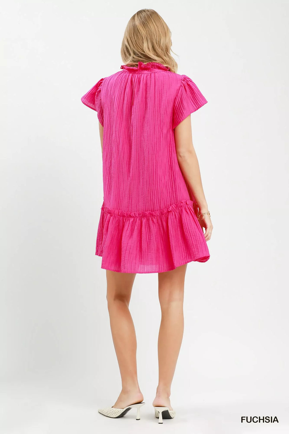 Back view of fuchsia textured mini dress with flutter cap sleeves and ruffle hem