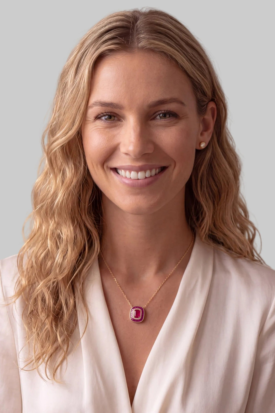 Gold chain ruby pendant necklace with red square pendant shown on a model