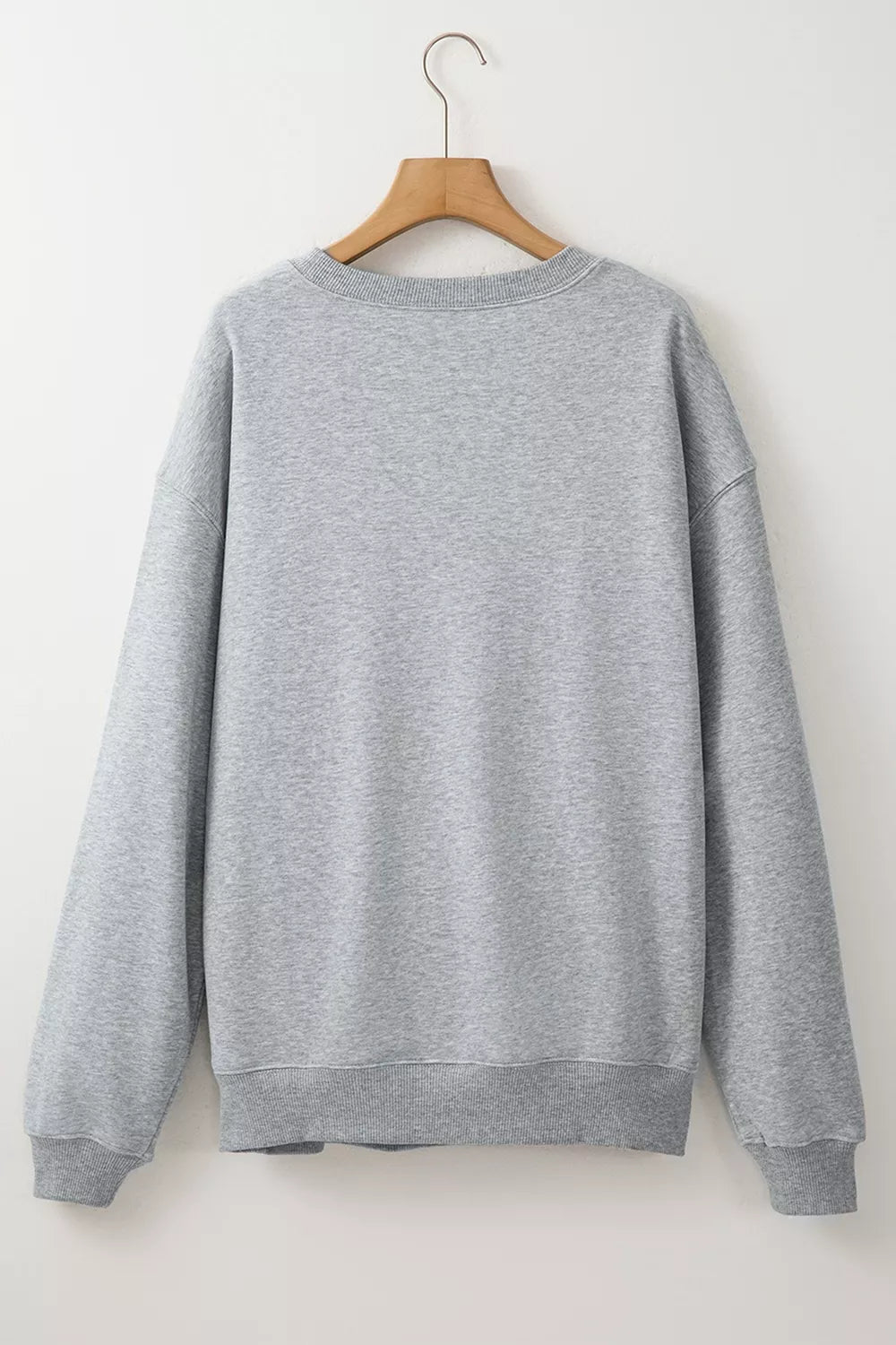 Gray oversized pullover sweatshirt back view hanging on a hanger