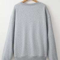 Gray oversized pullover sweatshirt back view hanging on a hanger