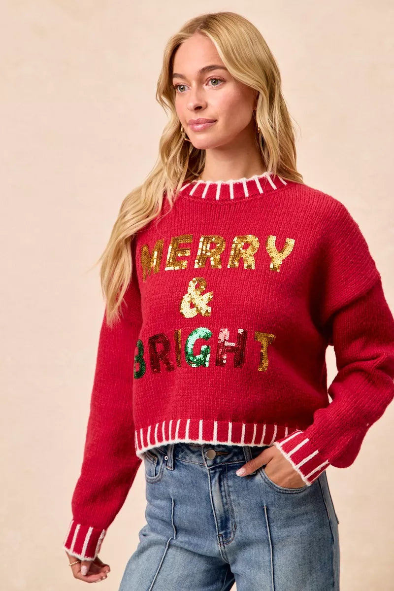 Red Christmas sweater front view, sequin “Merry & Bright” letters with striped trim