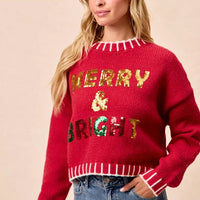 Red Christmas sweater front view, sequin “Merry & Bright” letters with striped trim