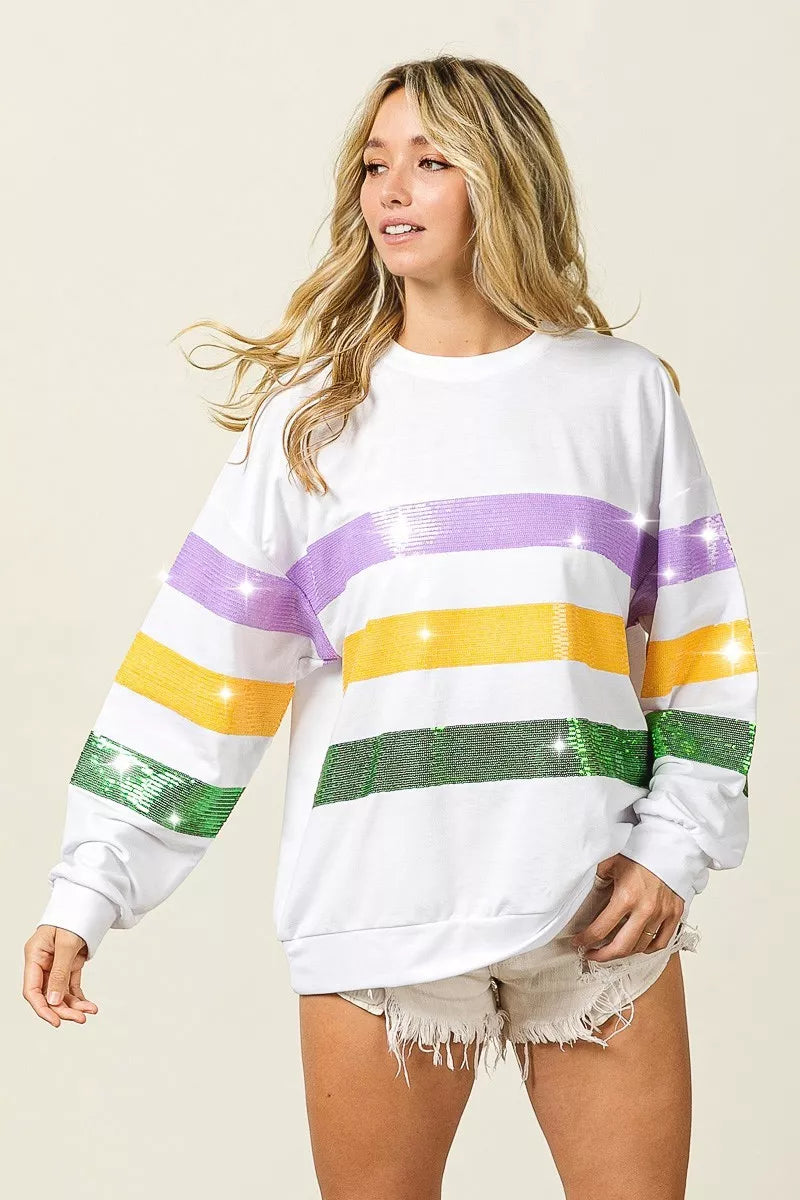 White pullover sweatshirt with sequin horizontal stripes across chest and long sleeves