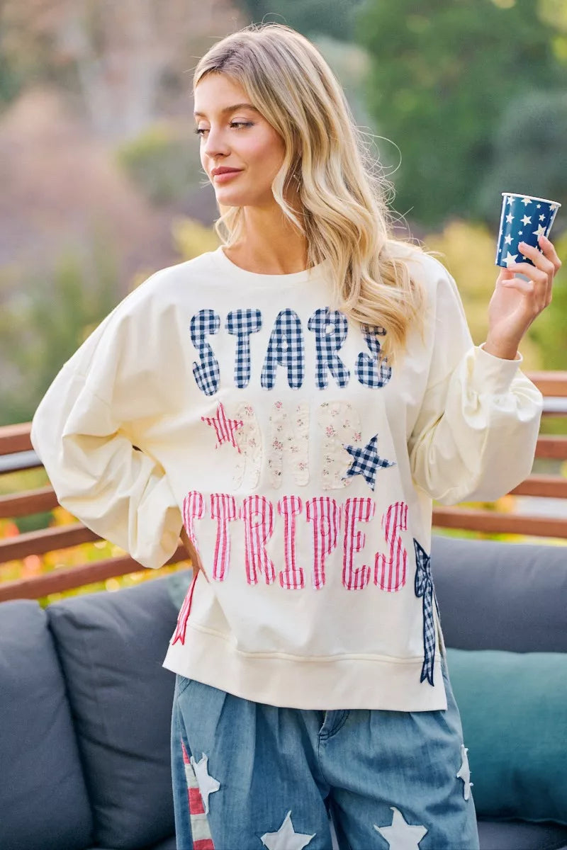 Cream crewneck sweatshirt with stars-and-stripes patch-style graphic, long sleeves