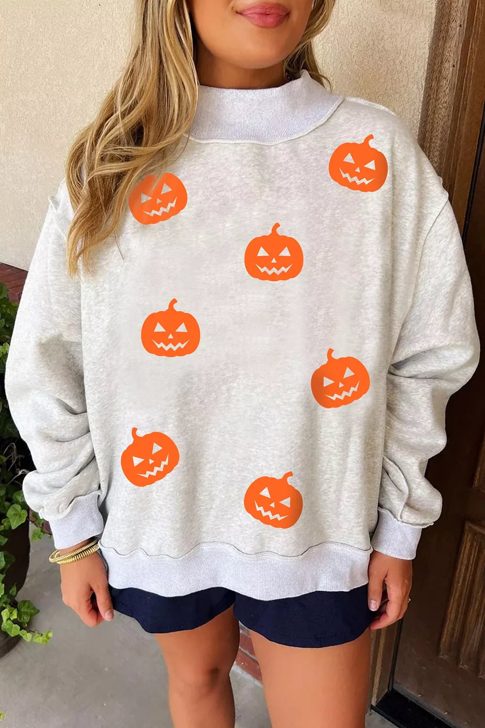 Light gray sweatshirt with scattered orange jack-o’-lantern face prints