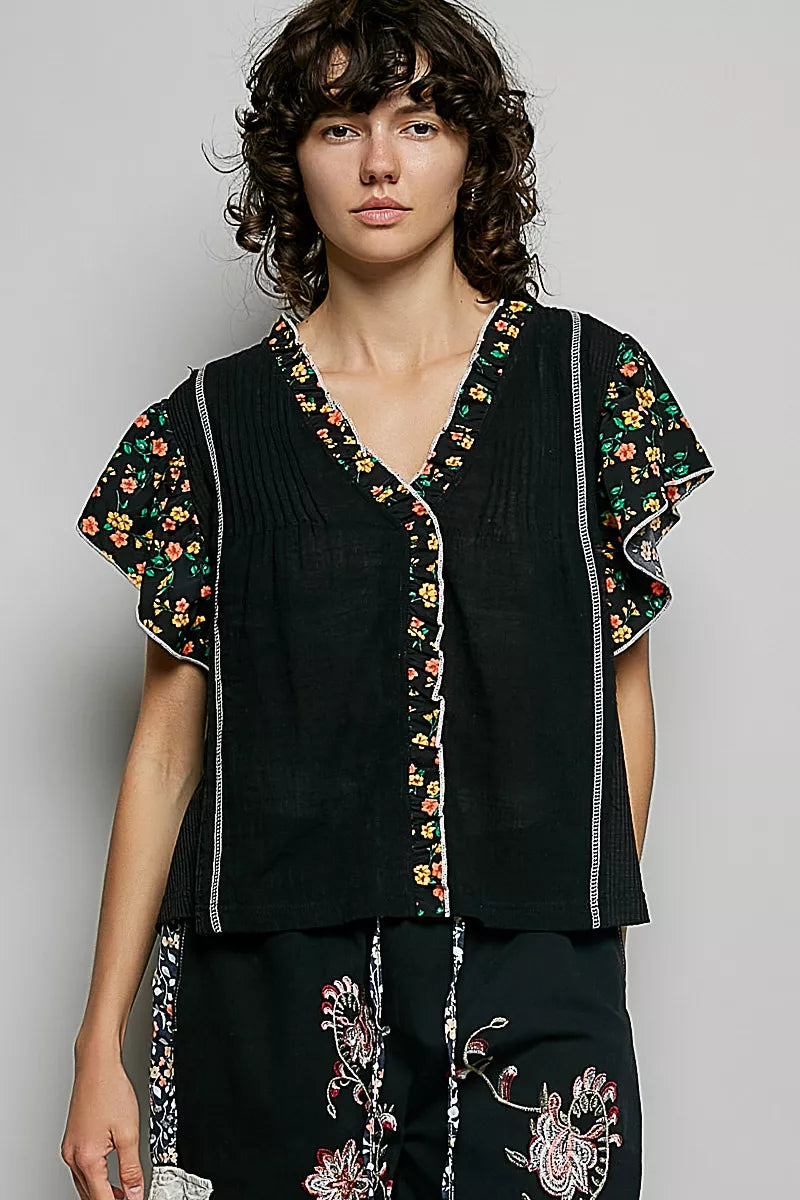 Black V-neck ruffle-sleeve blouse with floral trim and vertical piping