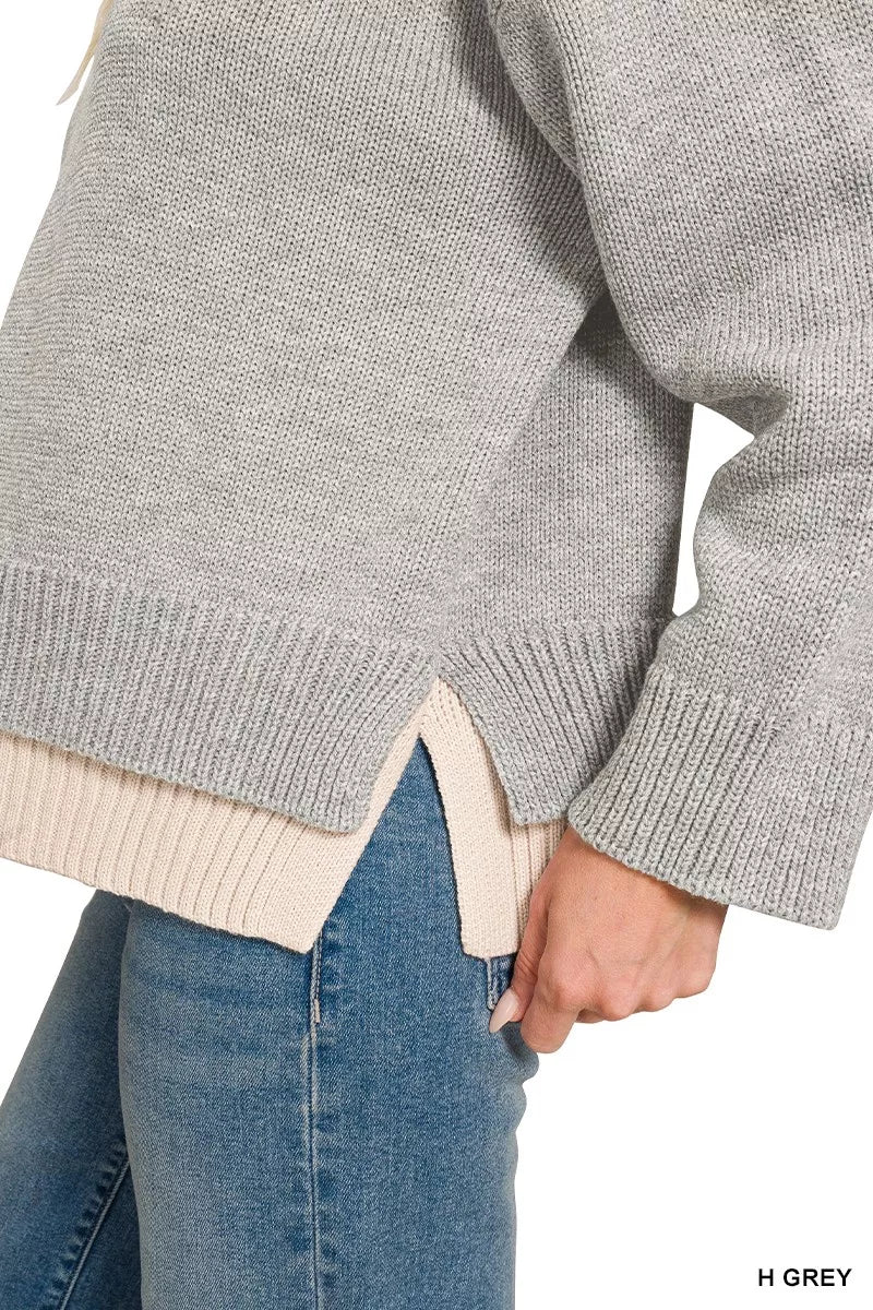 Grey sweater hem with beige ribbed contrast and slit detail, long sleeve cuff