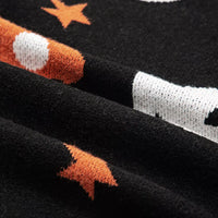 Black knit sleeve close-up with moon, star, and pumpkin-themed pattern detail