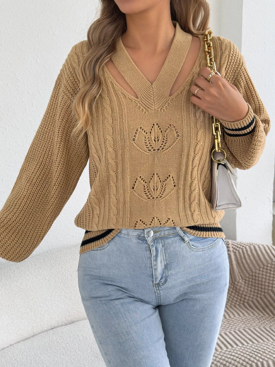 Camel cutout cable knit sweater with front knit floral designs and striped cuffs