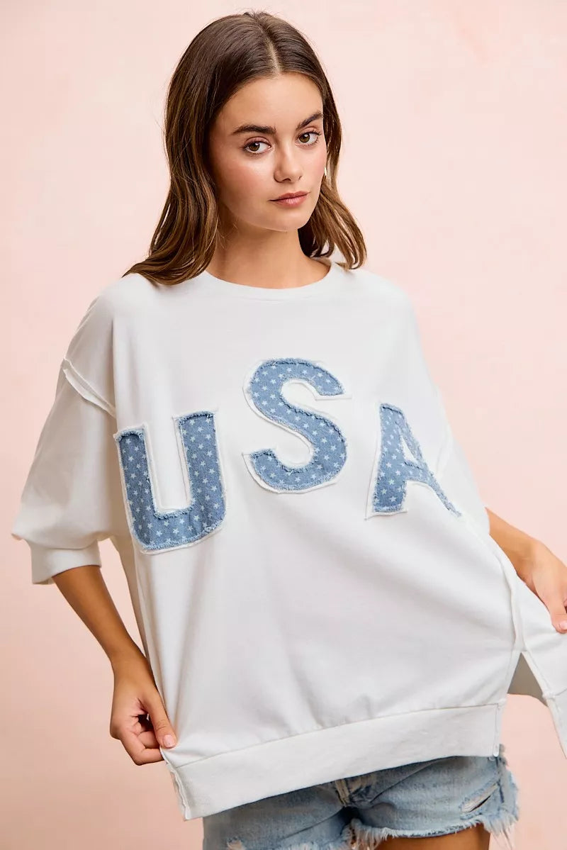 Ivory french terry pullover with blue "USA" patch letters and side slits near hem