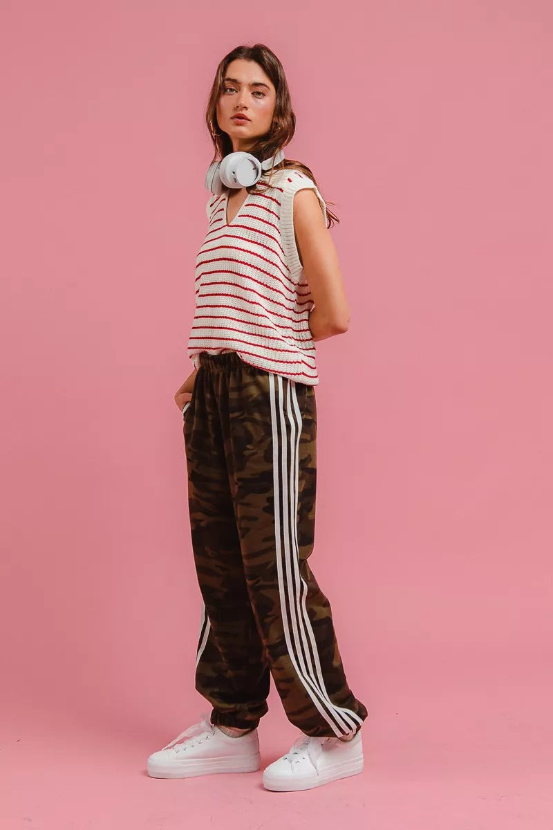 Camouflage track pants with white side stripes and cuffed ankle openings.