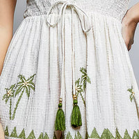 Natural palm tree print dress close-up: drawstring tie waist and ruffled skirt border
