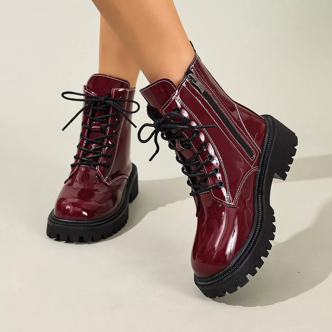 Burgundy patent lace-up block heel boots with black side panels and chunky tread sole