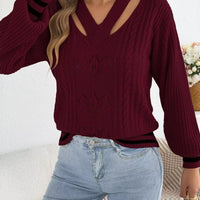 Burgundy cutout cable knit sweater with V-neck cutout, cable texture, and ribbed cuffs