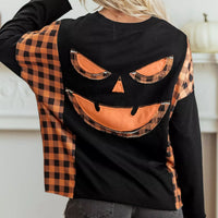 Black long-sleeve top with orange plaid pumpkin face graphic on the back