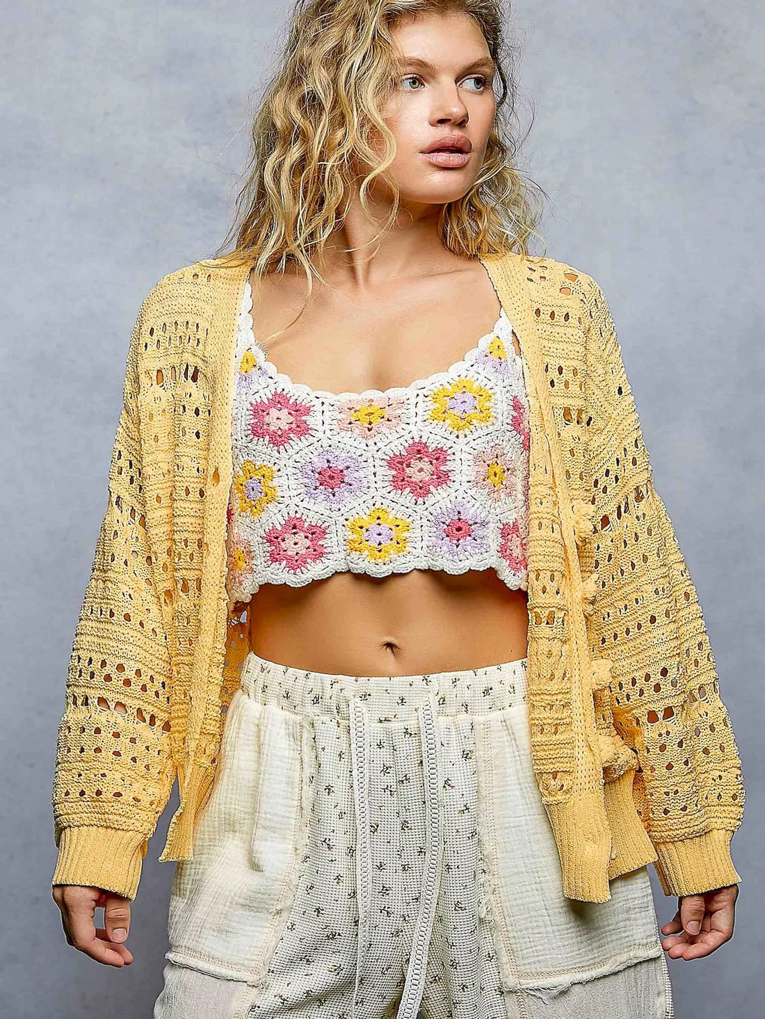 Yellow open-knit button cardigan with scalloped trim, long sleeves, and ribbed cuffs
