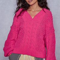 Fuchsia cable-knit cropped V-neck sweater with long sleeves and subtle cable stitch pattern