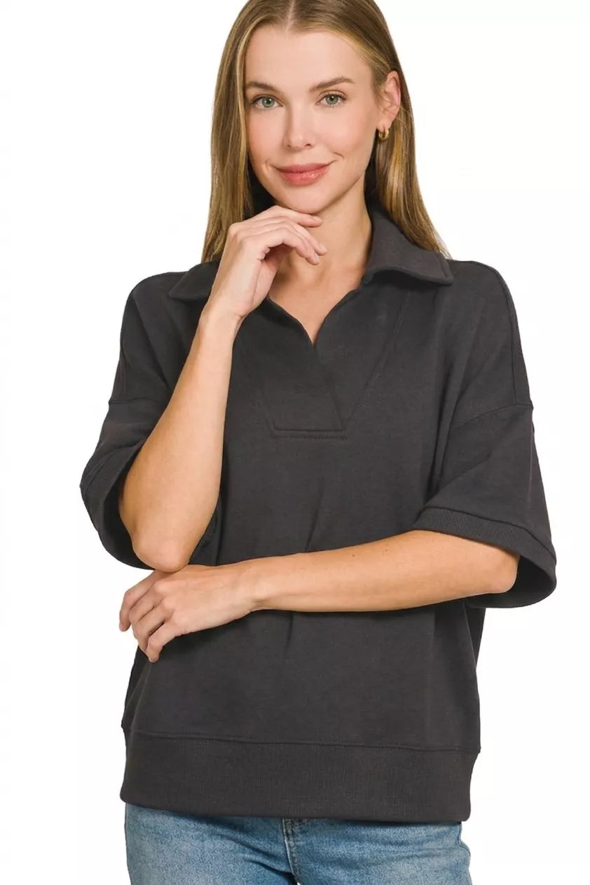 Black collared short-sleeve pullover with relaxed fit and half-zip neckline