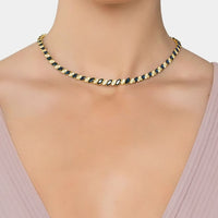 Gold tennis necklace with dark blue oval stones on a model’s neck