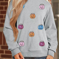 Gray long-sleeve sweatshirt with cartoon jack-o'-lantern and pumpkin face prints