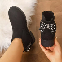 Black suede ankle boots with round toe, block heel, and jeweled bow ankle trim