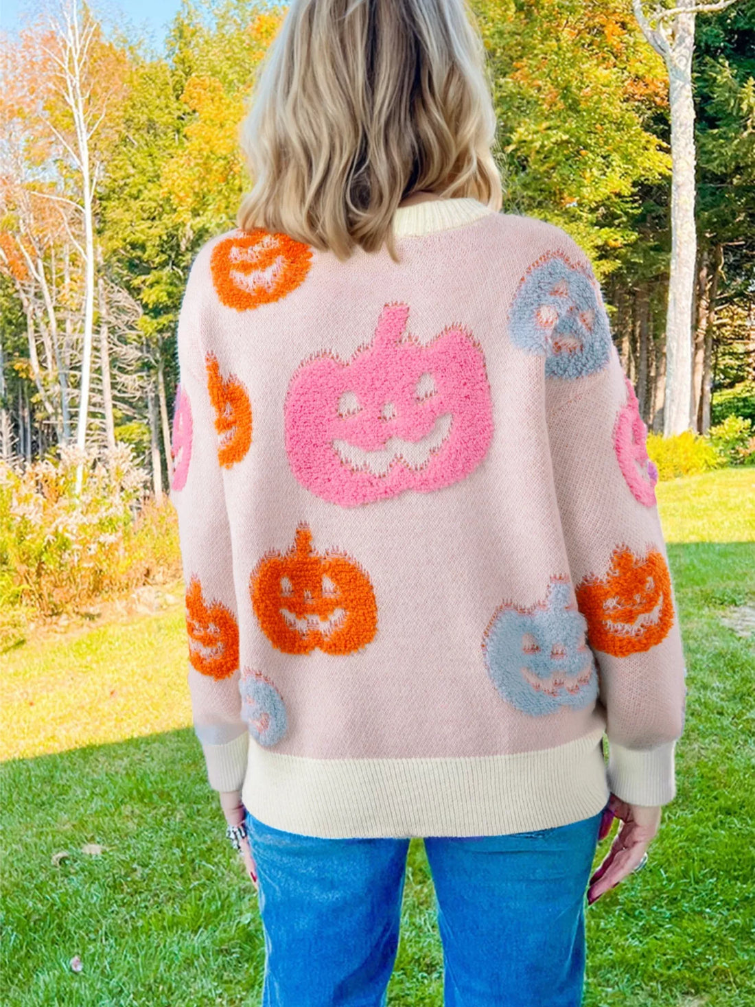 Dusty pink pumpkin knit sweater with jack-o’-lantern and ghost motif pattern on back