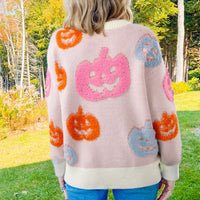Dusty pink pumpkin knit sweater with jack-o’-lantern and ghost motif pattern on back