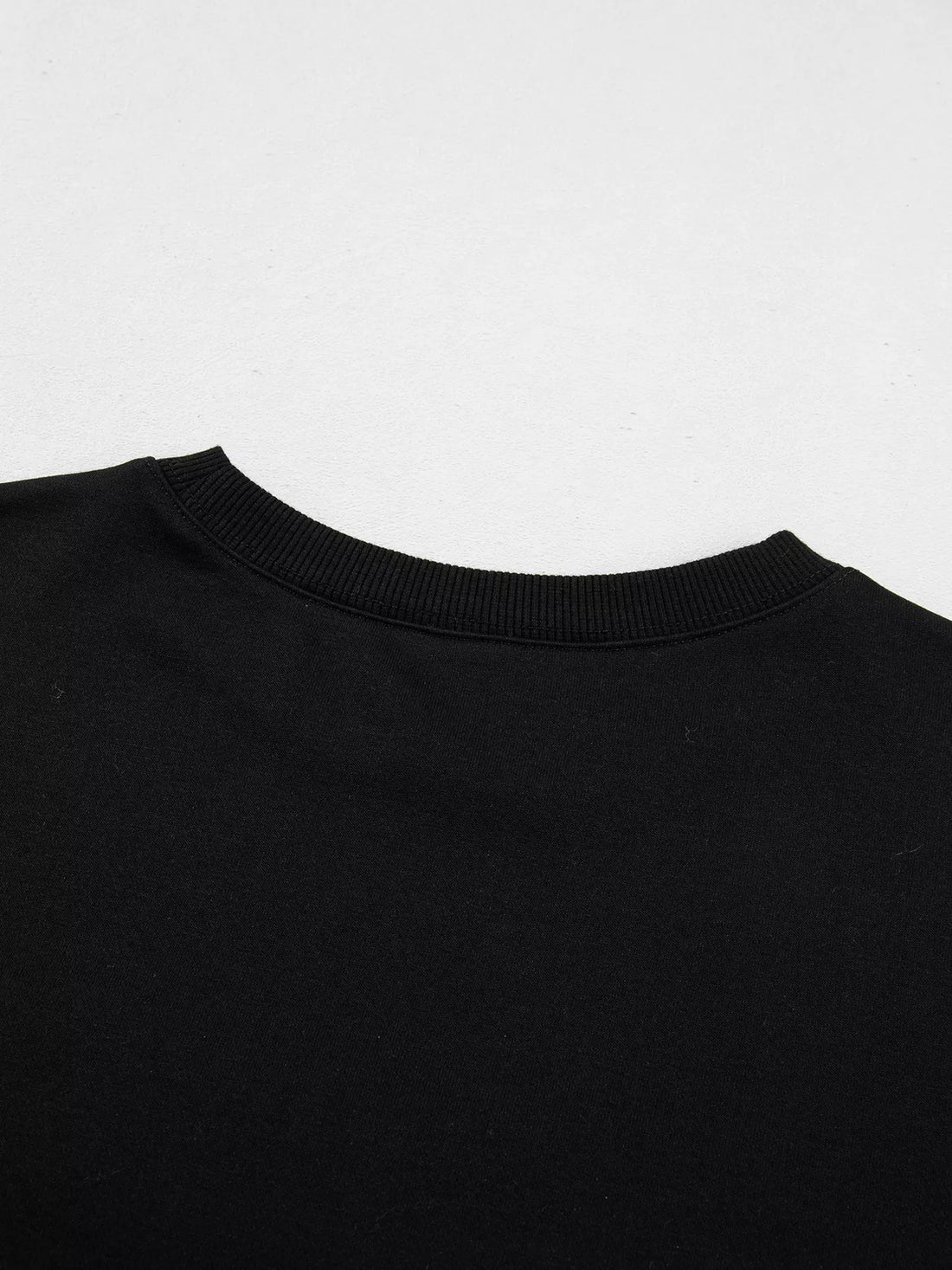 Black crewneck sweatshirt neckline ribbing close-up