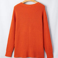Orange knit sweater on hanger, crew neck, ribbed hem and cuffs, long sleeves
