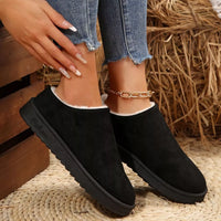 Black slip-on ankle boots with round toe and plush white lining at the collar.