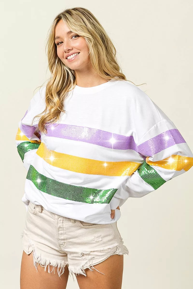 White pullover sweatshirt with wide sequin horizontal bands in purple, yellow, and green