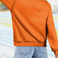 Orange mock neck sweatshirt, long sleeves, back view with curved hem