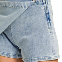 Light wash denim skort detail showing wrap flap and button at waistband