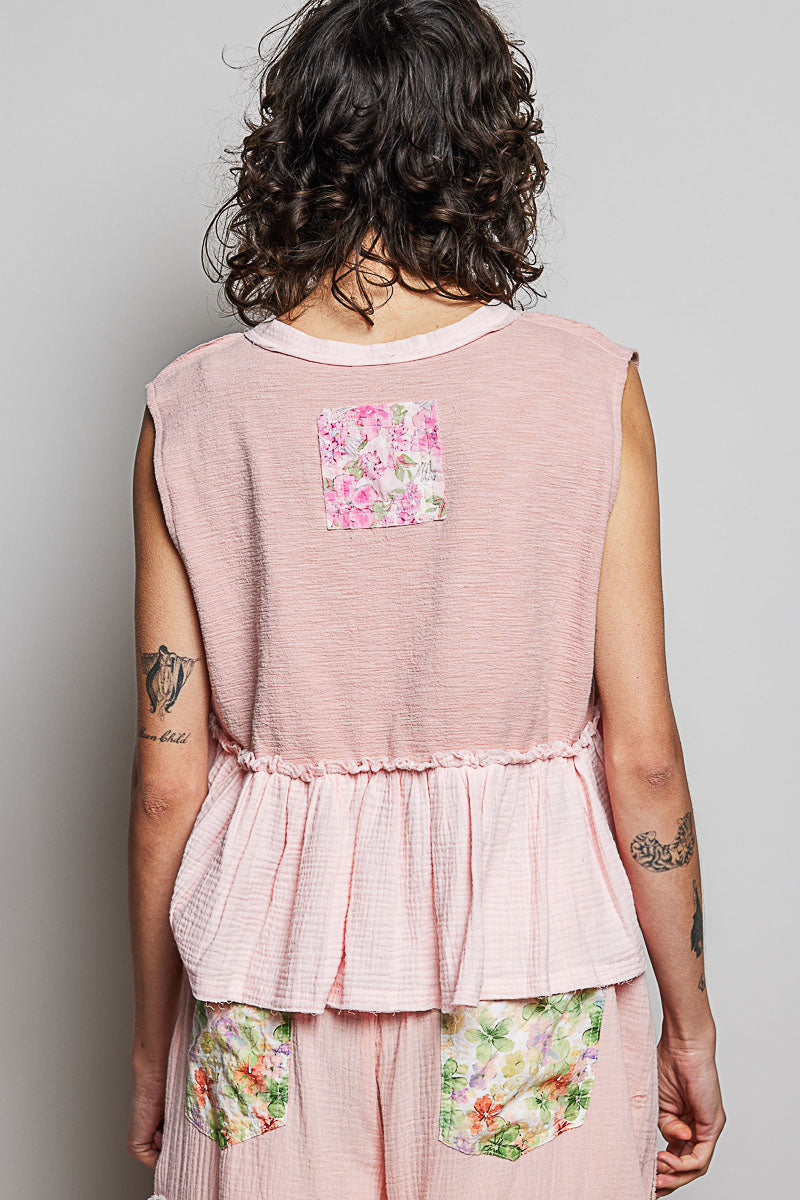 Powder pink sleeveless top, back view, gathered ruffle hem with floral patch pockets