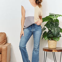 Color-block V-neck knit top with beige, gray, and white panels, short sleeves.