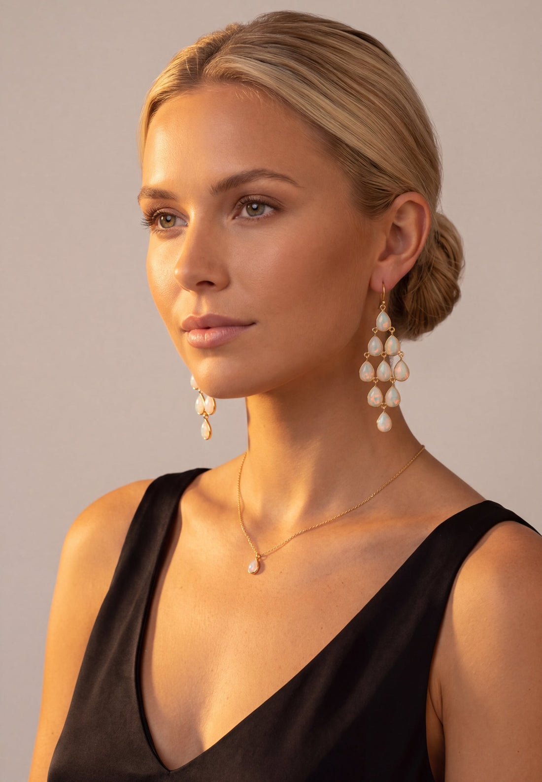 Gold-tone opal teardrop chandelier earrings worn, clustered dangling drops