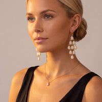 Gold-tone opal teardrop chandelier earrings worn, clustered dangling drops